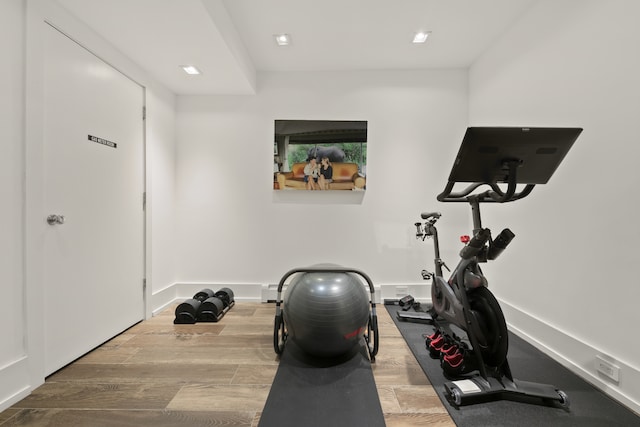 workout area with baseboards and wood finished floors