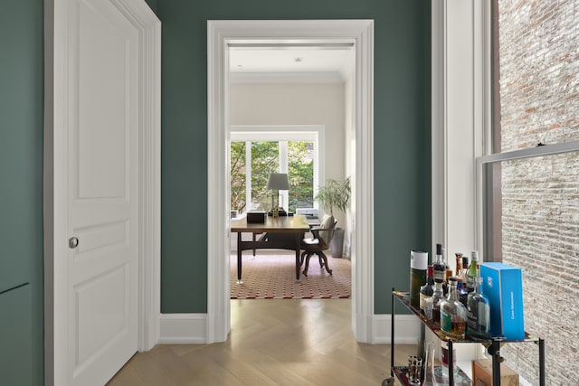 corridor featuring baseboards and crown molding