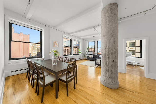 dining room with baseboard heating, ornate columns, light hardwood / wood-style flooring, and beamed ceiling