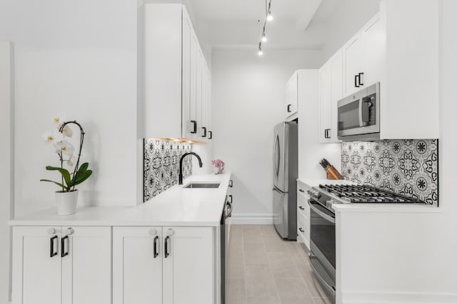 kitchen featuring light countertops, appliances with stainless steel finishes, a sink, and white cabinets