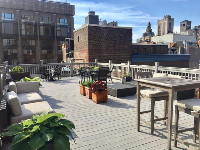 wooden deck with a view of city, outdoor dining area, and an outdoor hangout area