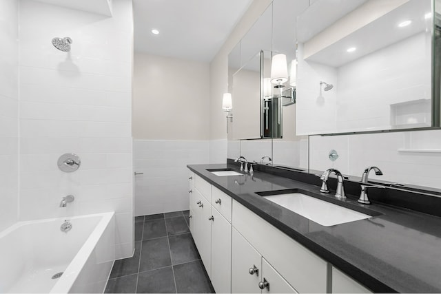 full bathroom featuring tile patterned flooring, tile walls, double vanity, and a sink