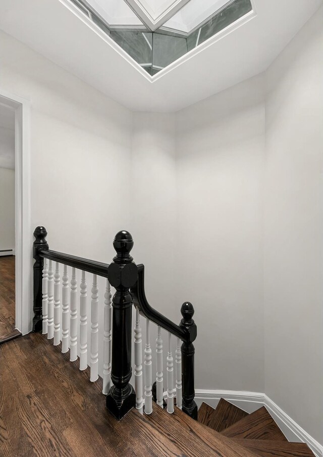 bedroom with ceiling fan, baseboard heating, and dark hardwood / wood-style floors