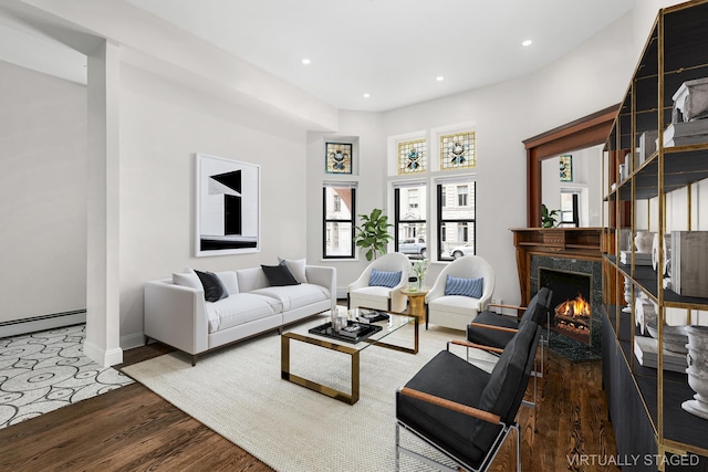 living room with baseboard heating, recessed lighting, a fireplace, and wood finished floors