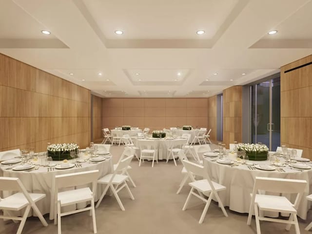 dining room featuring wooden walls, a tray ceiling, and concrete floors