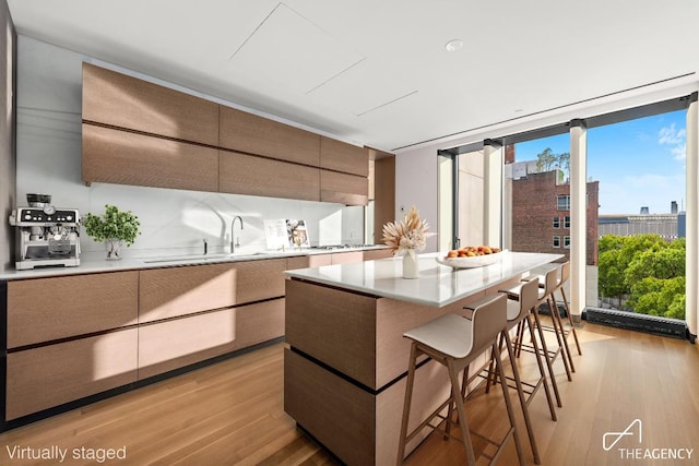 kitchen with a view of city, light countertops, a breakfast bar area, and modern cabinets