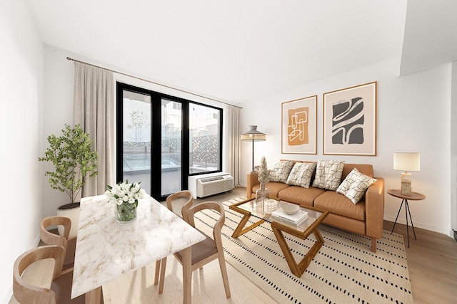 living room with light hardwood / wood-style flooring and an AC wall unit