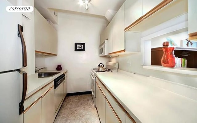 kitchen with stainless steel appliances, white cabinetry, and sink