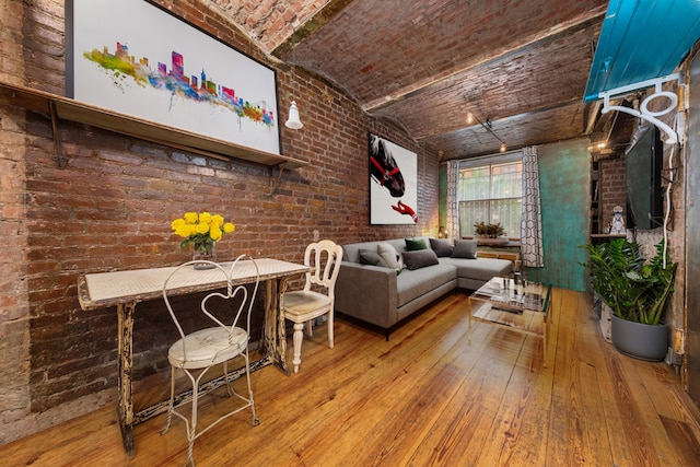 living room with lofted ceiling, brick ceiling, wood-type flooring, and brick wall