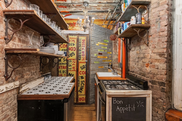 interior space with brick wall, brick ceiling, sink, and range with gas stovetop