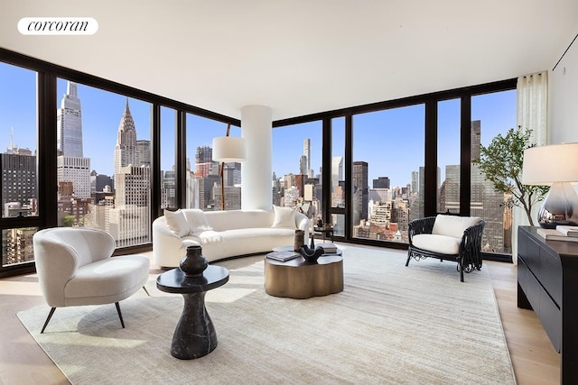 living room with a view of city, light wood-type flooring, and floor to ceiling windows