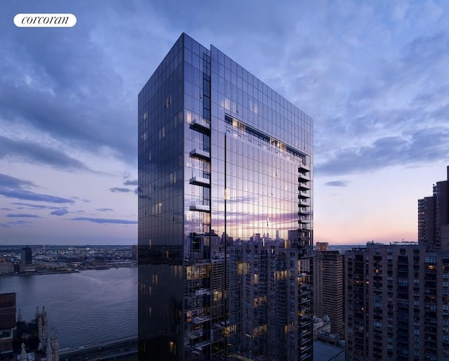 property at dusk with a view of city and a water view