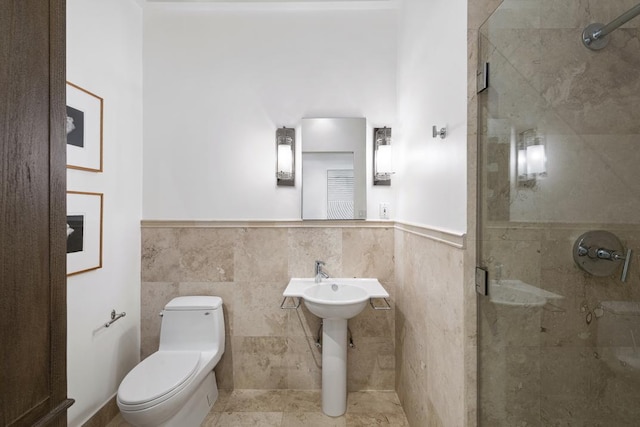 bathroom with tile walls, tile patterned flooring, a shower with shower door, and toilet