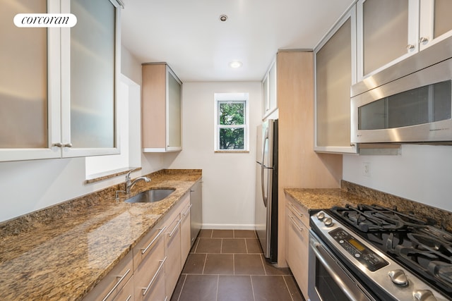 2279 3rd Ave Unit 3C, New York City, NY 10035 - kitchen with appliances with stainless steel finishes, a sink, light stone countertops, baseboards, and dark tile patterned flooring
