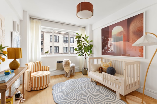 sitting room featuring a wall mounted air conditioner and wood finished floors