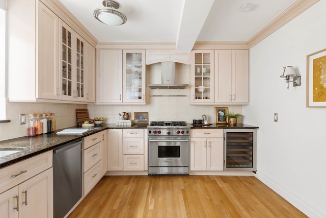 kitchen with wall chimney range hood, tasteful backsplash, stainless steel appliances, light wood-type flooring, and wine cooler