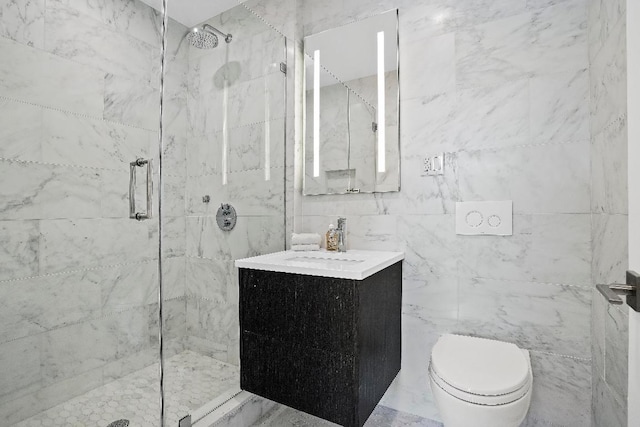 bathroom featuring vanity, toilet, a shower with shower door, and tile walls