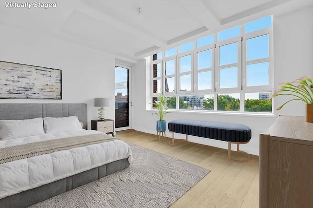 bedroom featuring beamed ceiling and light hardwood / wood-style flooring