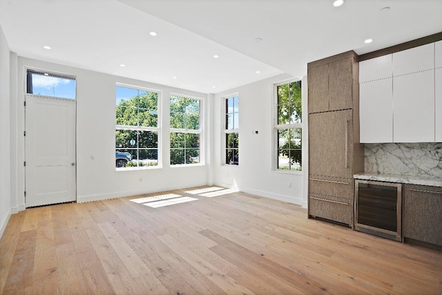 interior space with beverage cooler and light hardwood / wood-style flooring