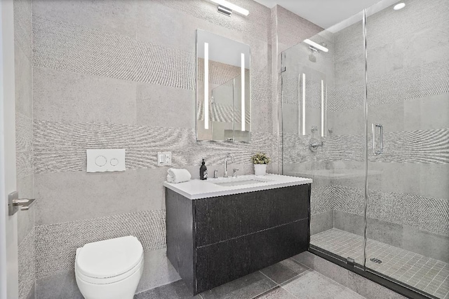 bathroom with an enclosed shower, vanity, tile walls, and toilet