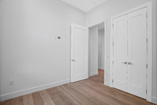 unfurnished bedroom with a closet and light hardwood / wood-style flooring