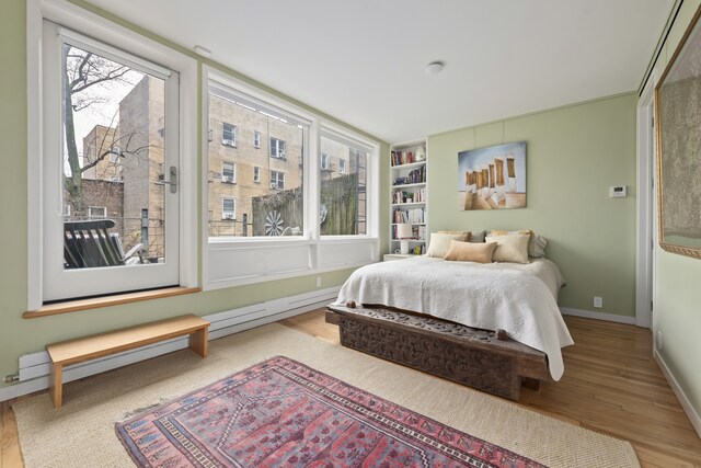 bedroom featuring a nursery area and light hardwood / wood-style floors