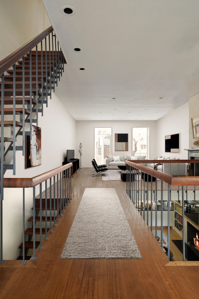 hall with an upstairs landing and hardwood / wood-style flooring