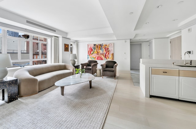 living area featuring a raised ceiling and recessed lighting