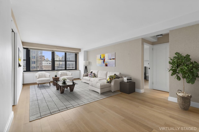 living room with baseboards, light wood finished floors, and a city view