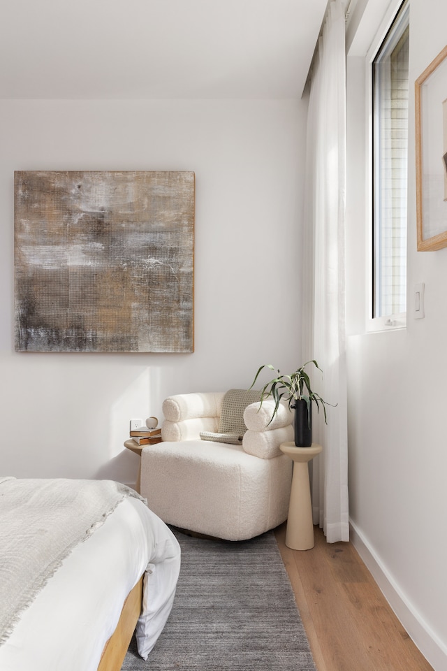 bedroom with light wood-type flooring and baseboards