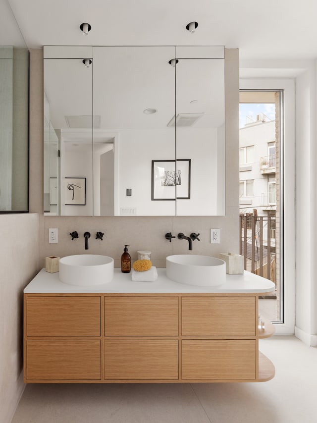 bathroom featuring double vanity, visible vents, and a sink