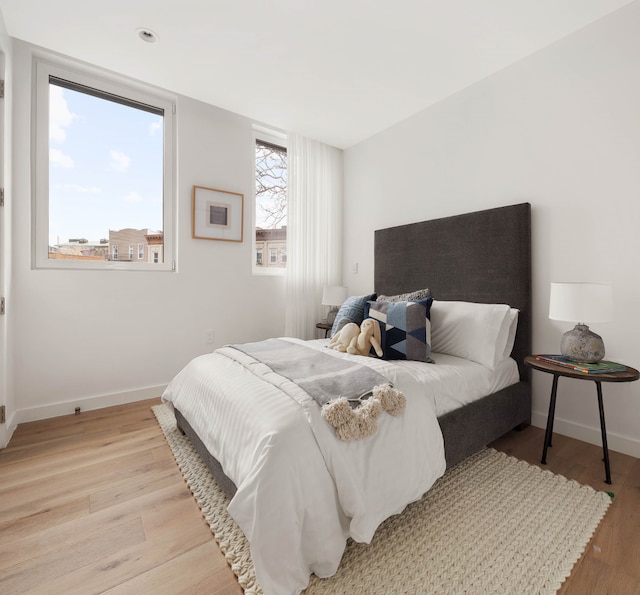 bedroom featuring light wood-style flooring and baseboards