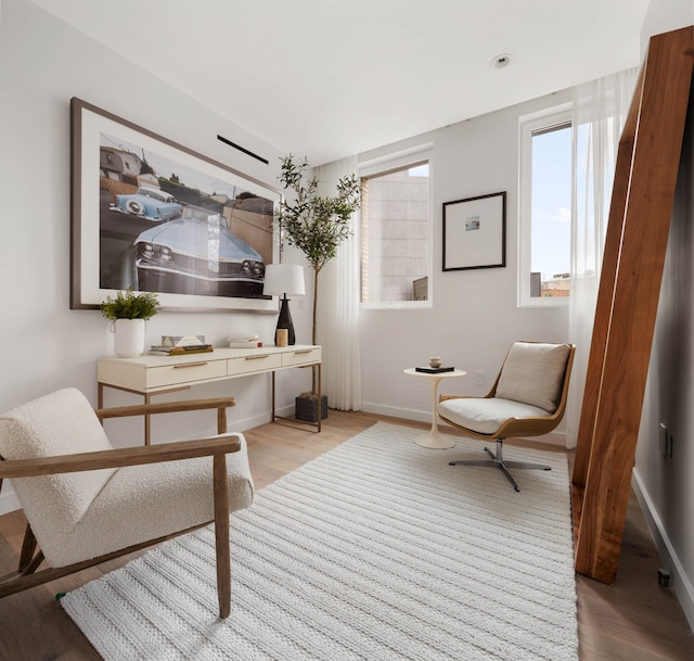 living area with light wood-type flooring and baseboards