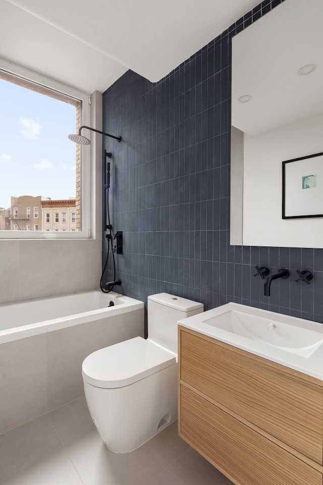 bathroom with toilet, vanity, tile walls, and tile patterned floors