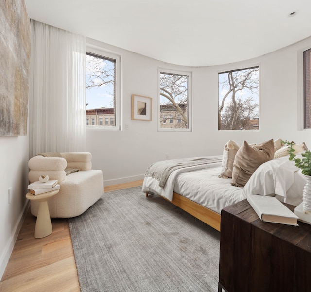 bedroom with light wood-type flooring and multiple windows