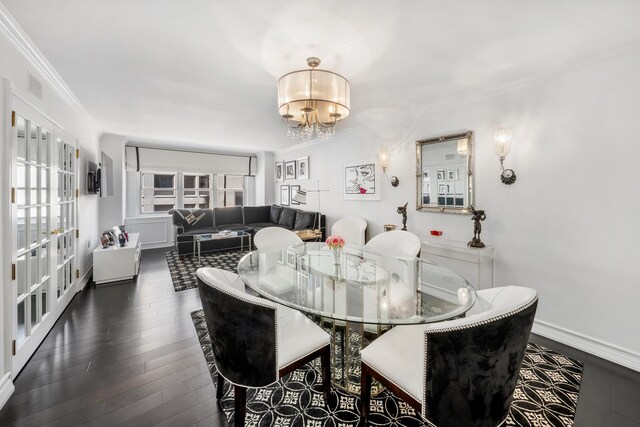 dining room with ornamental molding, dark hardwood / wood-style floors, and a notable chandelier