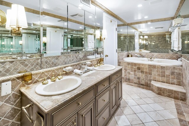 bathroom featuring tasteful backsplash, vanity, and tiled tub