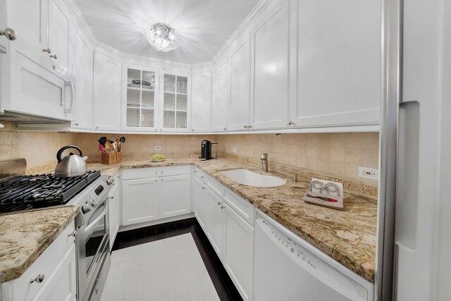 kitchen featuring tasteful backsplash, sink, white appliances, and white cabinets