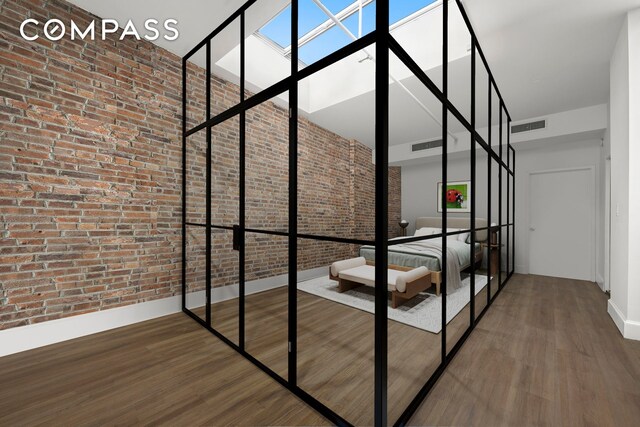 dining area featuring dark hardwood / wood-style flooring, a high ceiling, and brick wall