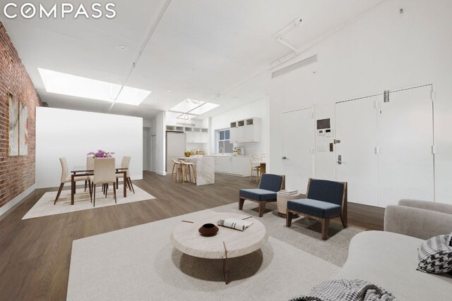 bedroom featuring hardwood / wood-style flooring and brick wall