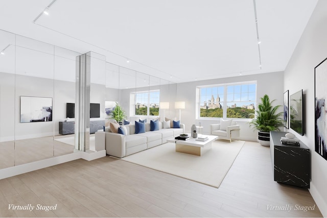 living area with wood finished floors and rail lighting