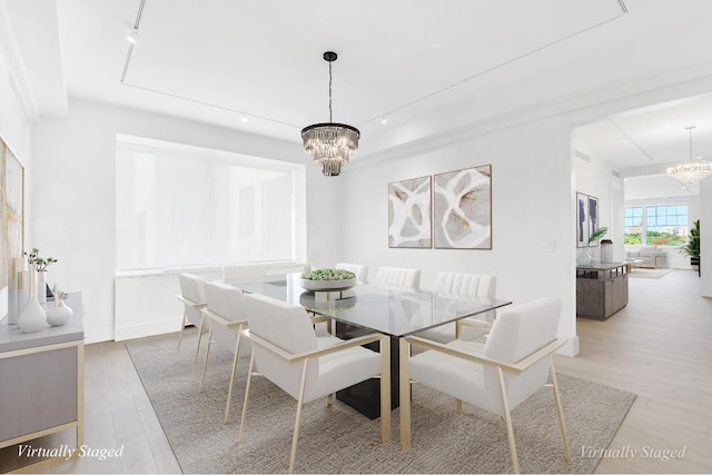 dining space featuring an inviting chandelier and light hardwood / wood-style flooring