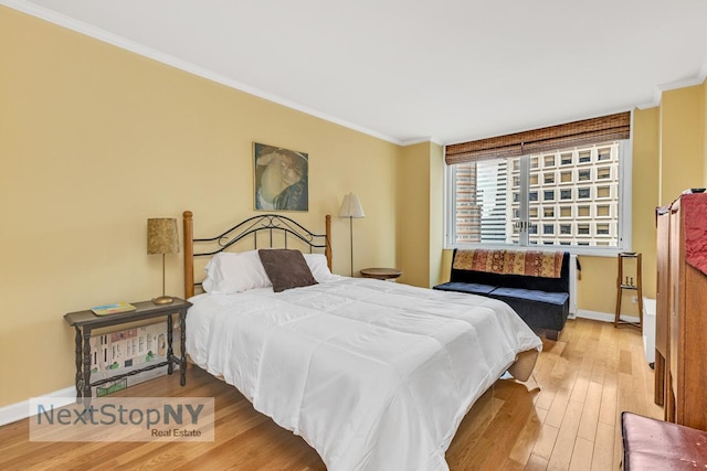 bedroom with crown molding, baseboards, and hardwood / wood-style floors