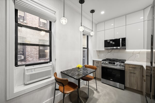 kitchen featuring pendant lighting, appliances with stainless steel finishes, modern cabinets, white cabinets, and cooling unit