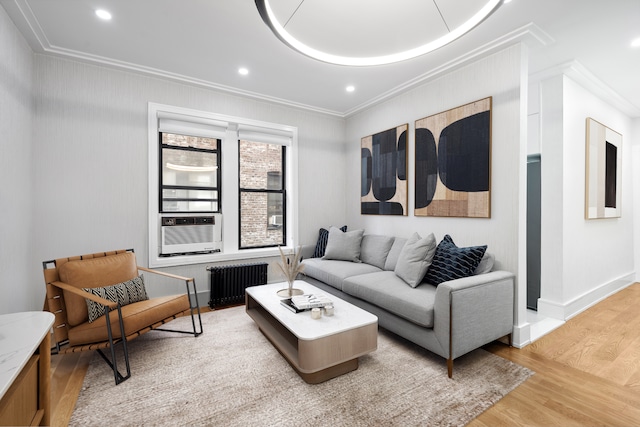 living area featuring light wood-style floors, baseboards, radiator heating unit, ornamental molding, and recessed lighting