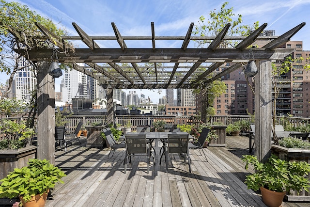 wooden terrace featuring a pergola, a city view, and outdoor dining space