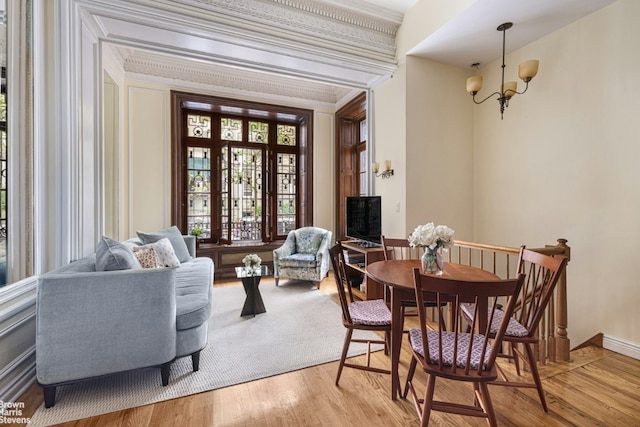 dining room with light hardwood / wood-style flooring, crown molding, and a chandelier