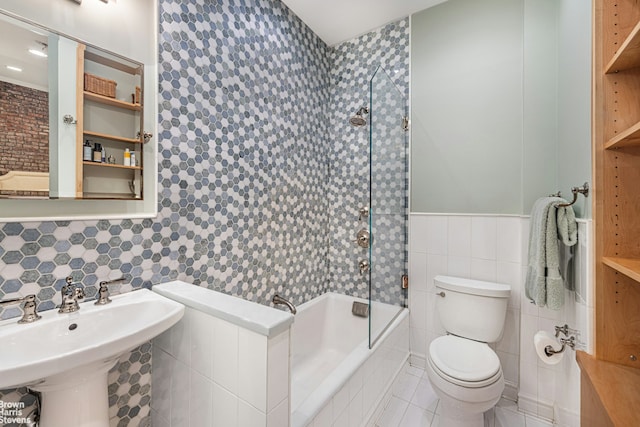 full bathroom featuring tile walls, toilet, tub / shower combination, a sink, and tile patterned flooring