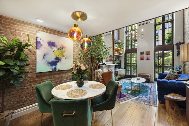 dining room with hardwood / wood-style flooring and brick wall