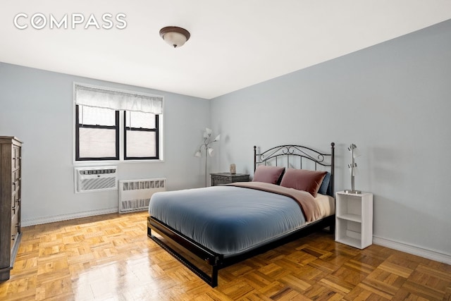 bedroom featuring radiator, parquet floors, and a wall unit AC